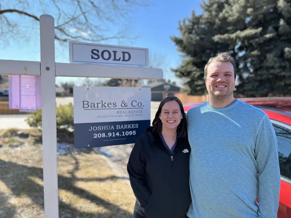 Repeat clients celebrating a record-breaking home sale in front of their mid-century ranch on the West Bench.