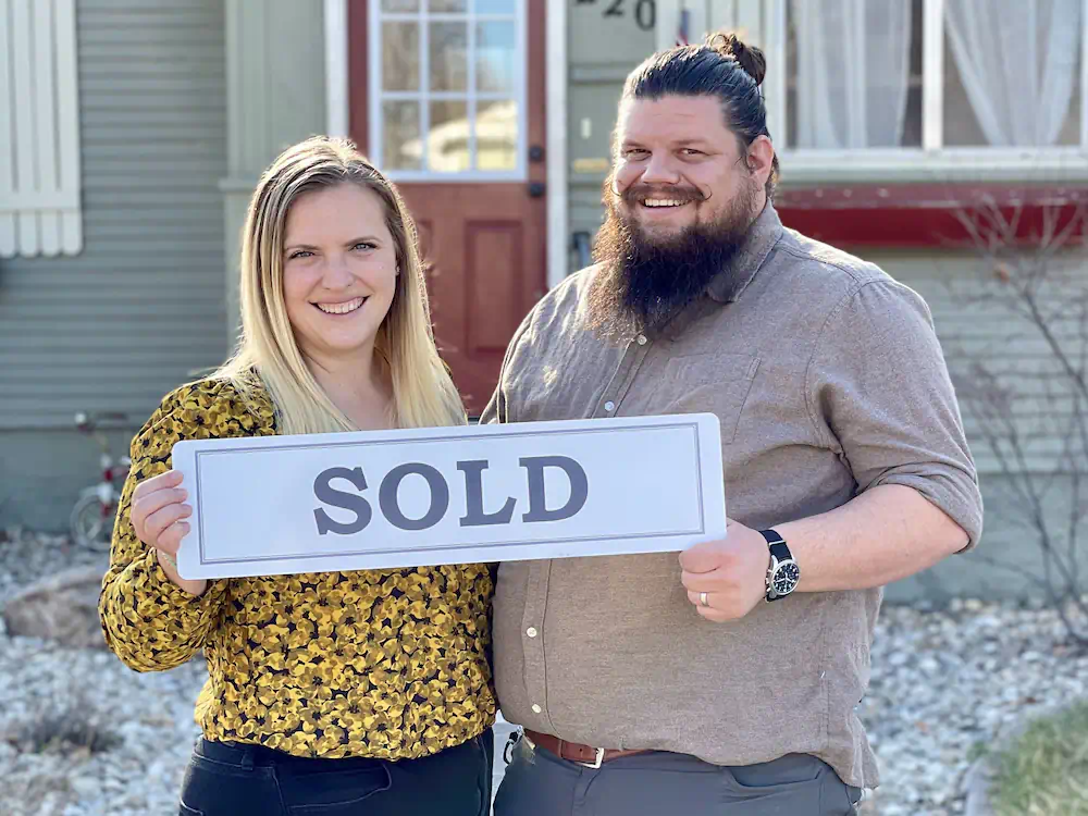 The Hernandez family holding a sold sign in front of their 1920's Bungalow in Nampa's downtown historic district.